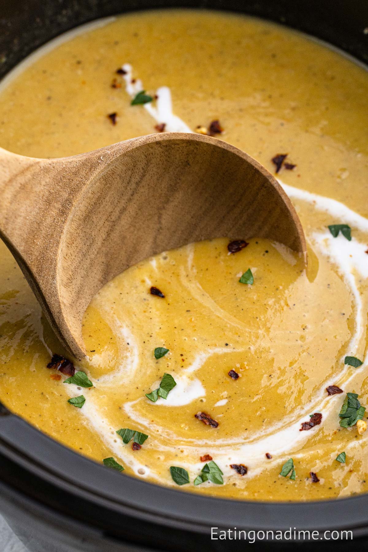 Butternut squash in the slow cooker with a wooden ladle