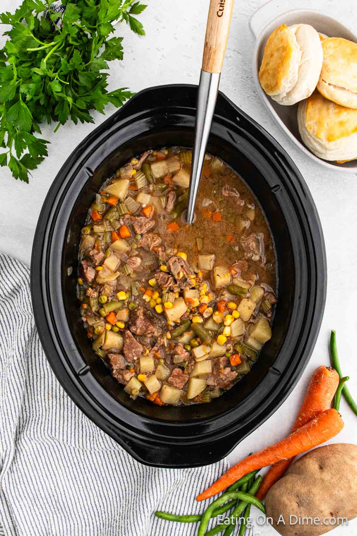 Ingredients in the slow cooker with a silver spoon