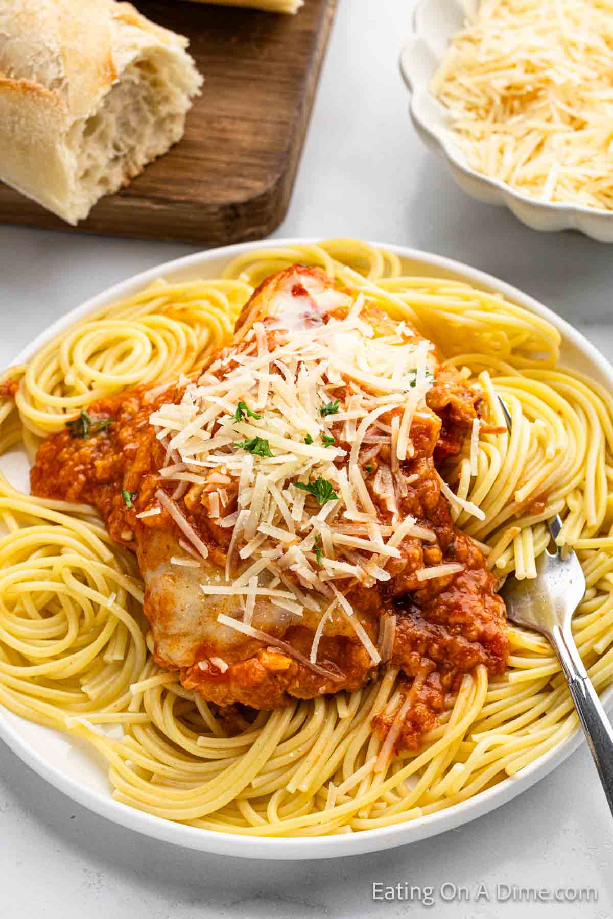 Chicken Parmesan on top of spaghetti noodles on a plate