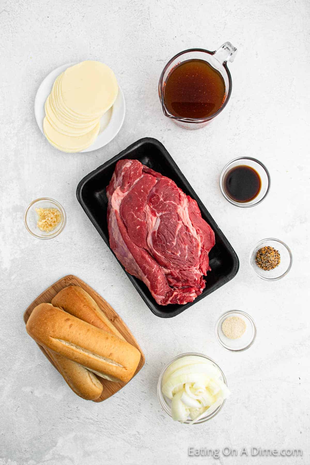 Ingredients for shredded beef sandwich - beef roast, onion, steak seasoning, minced garlic, worcestershire sauce, onion powder, beef broth, hoagie rolls, provolone cheese