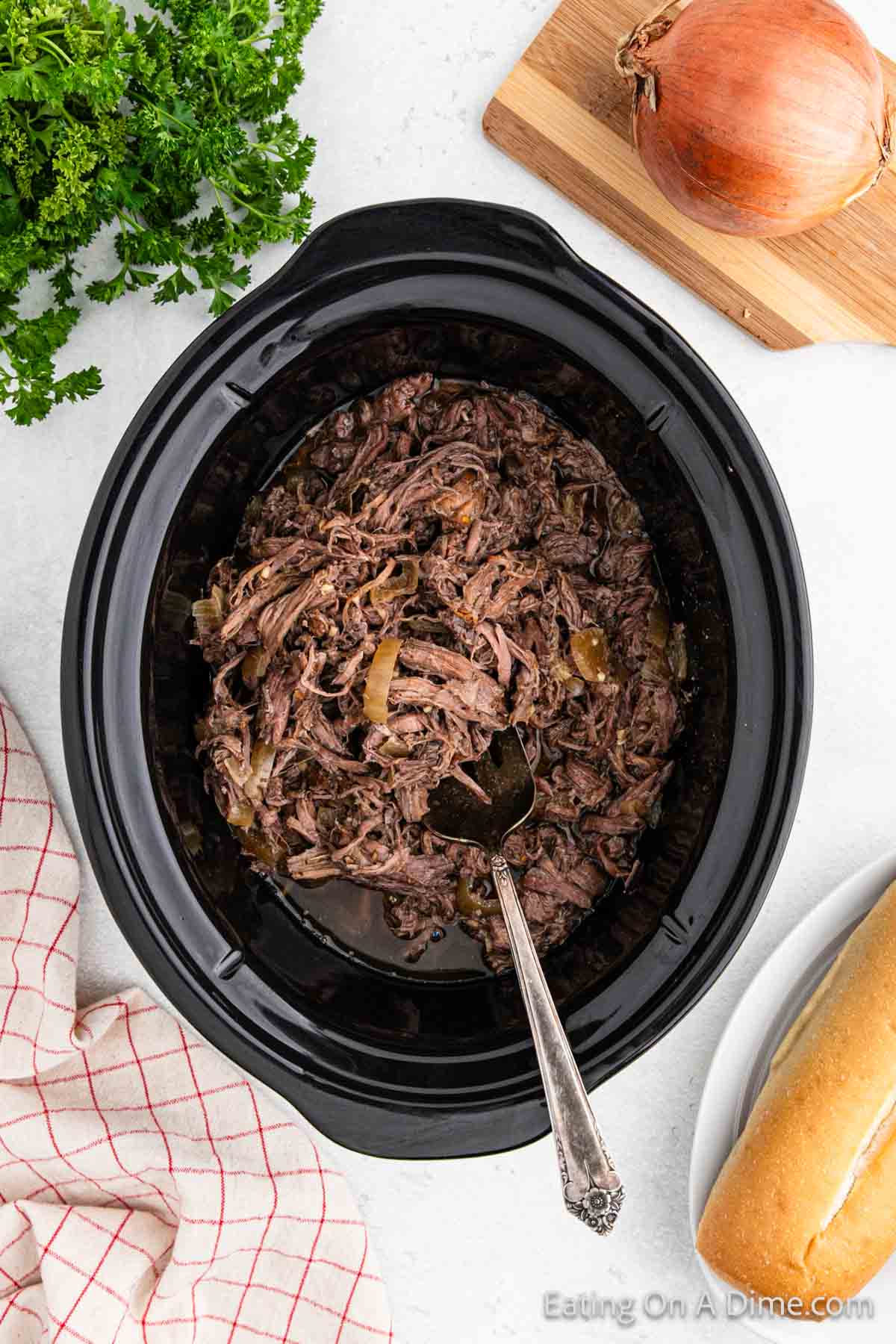 Shredded beef in the slow cooker with a spoon