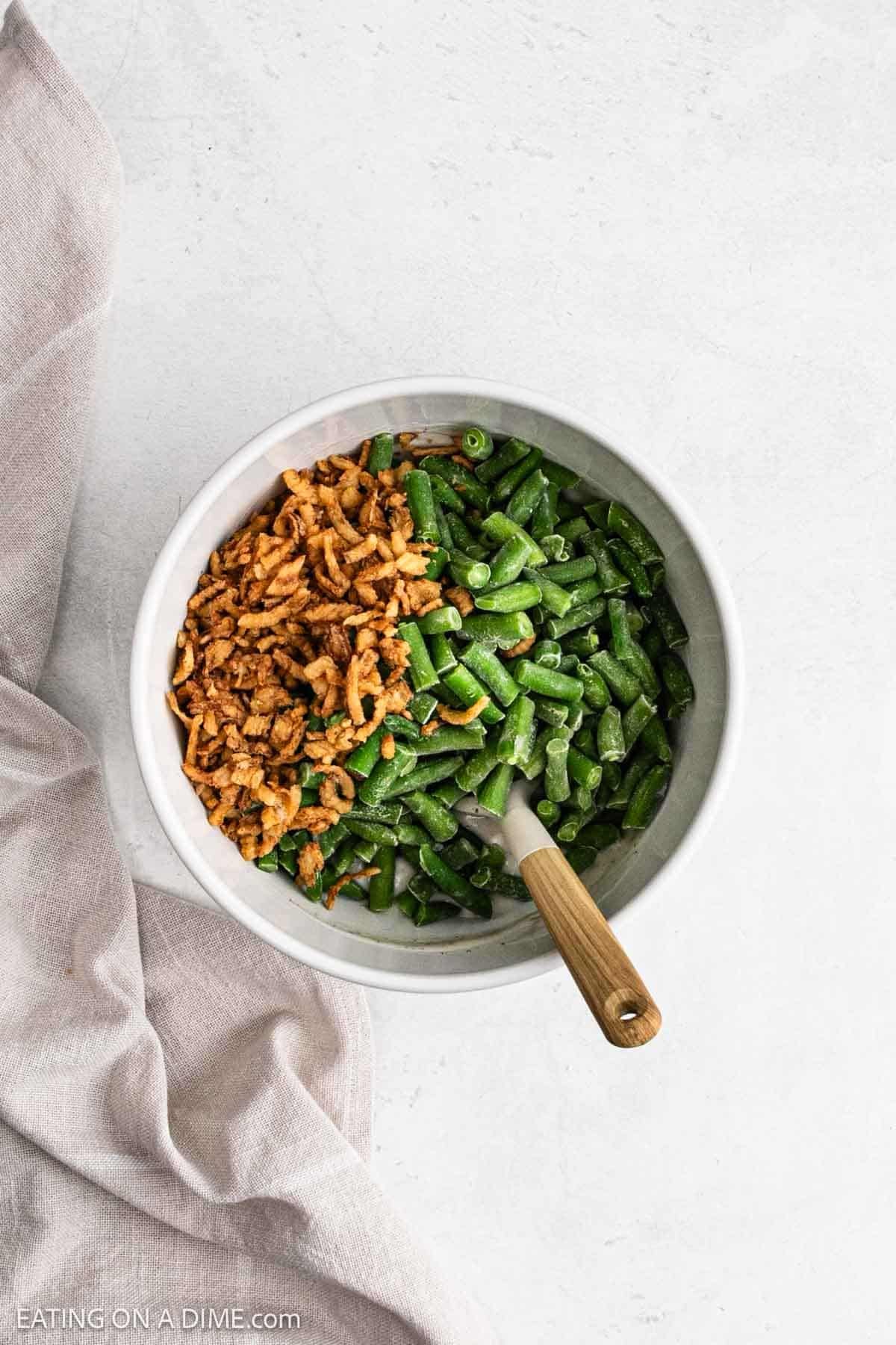 French fried onions and green beans have been added to the bowl.