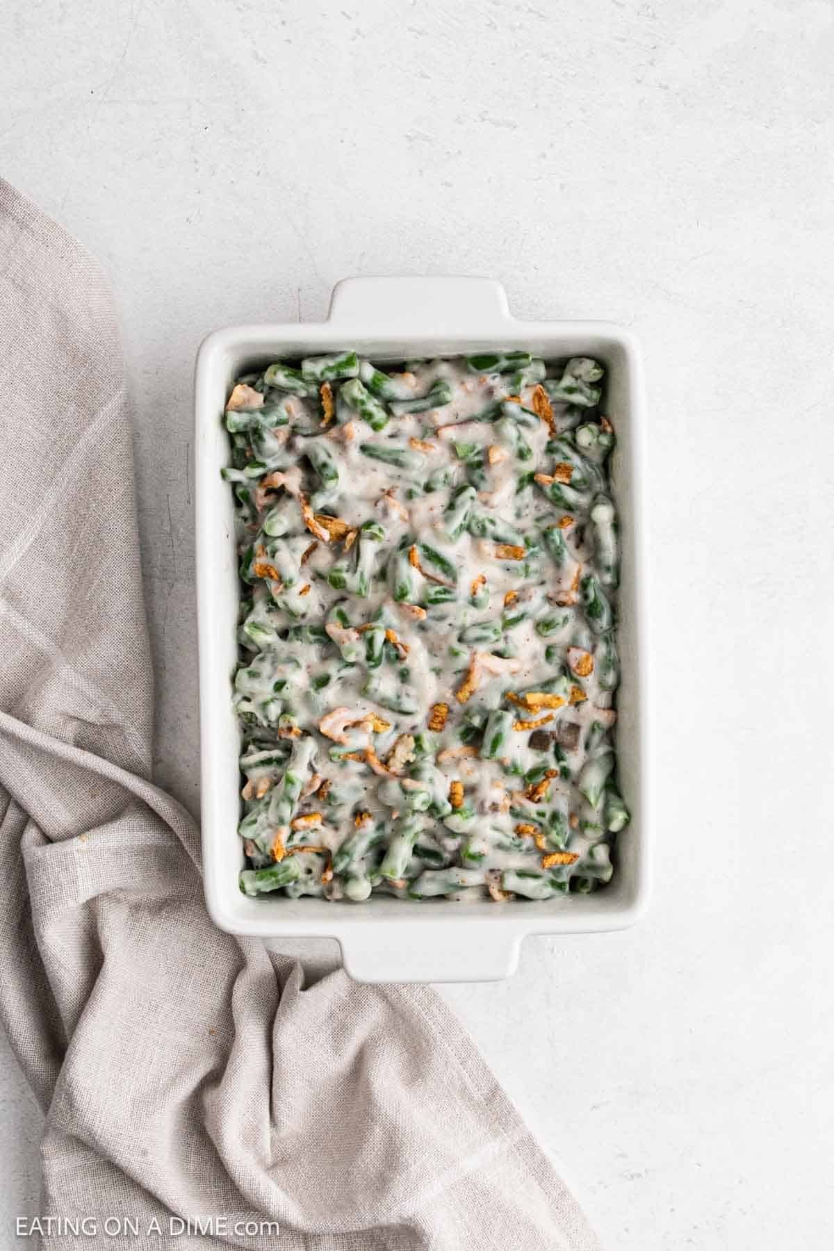 Spreading the green bean mixture into a baking dish.
