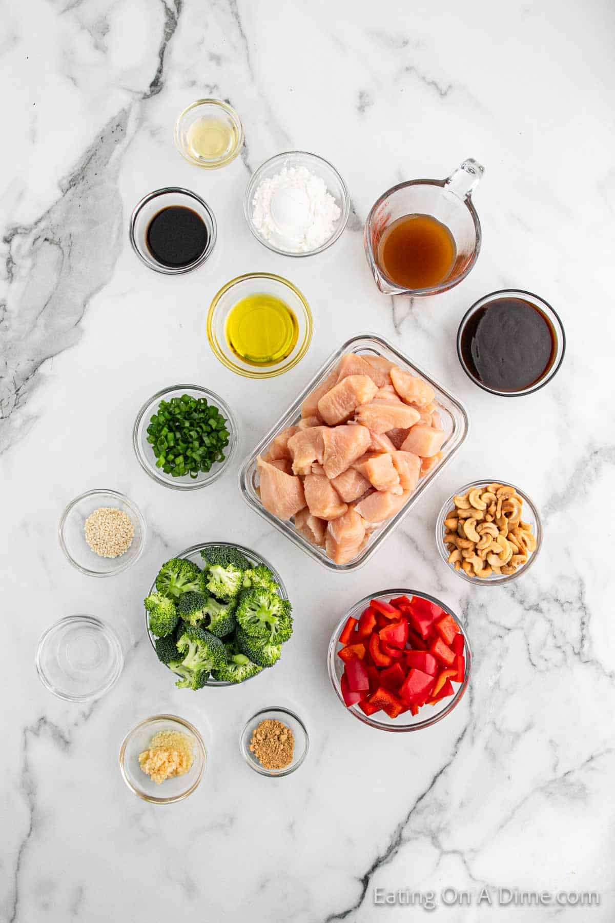 Cashew Chicken Ingredients - Chicken breasts diced into pieces, cornstarch, olive oil, chicken broth, hoisin sauce, soy sauce, rice vinegar, sesame oil, minced garlic, ground ginger, broccoli, red bell pepper, cashew halves, green onions, sesame seeds