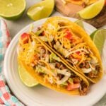 Taco shells with ground beef, shredded cheese, lettuce, and tomatoes.