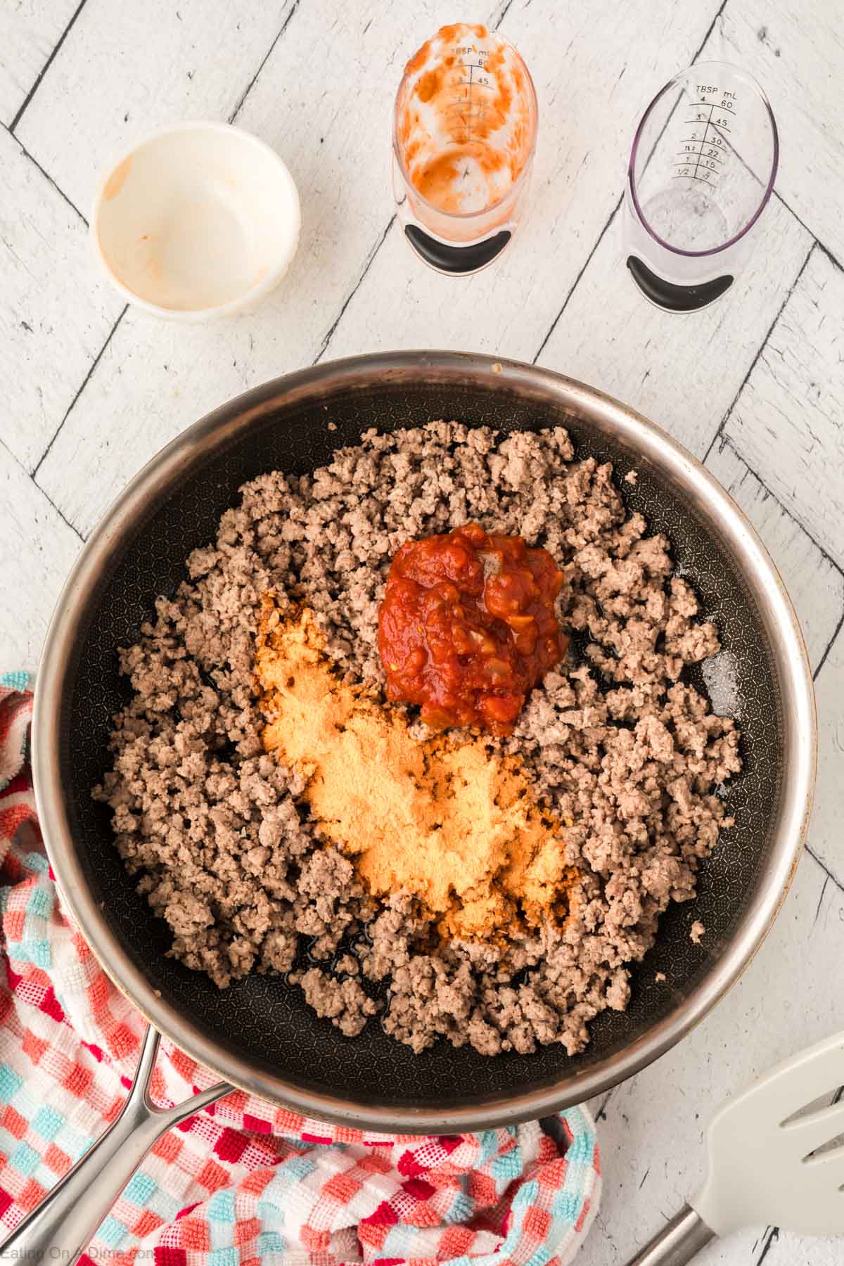 Adding in the salsa, water, and taco seasoning to the ground beef