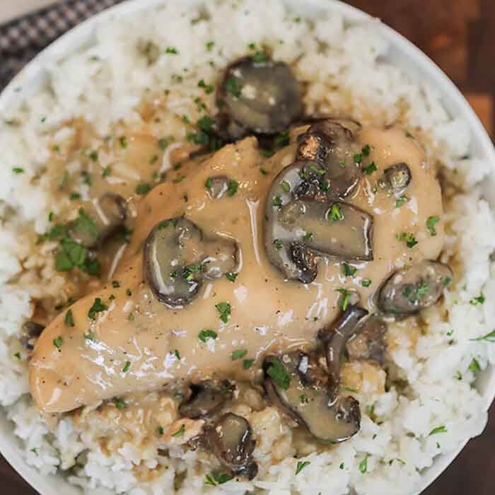 Crock pot smothered chicken with mushrooms is a really easy recipe with lots of tender chicken with gravy. Creamy Mushroom Chicken is amazing over rice and the entire dinner is effortless.  Try easy chicken and mushrooms for the best slow cooker meal. Smothered chicken with cream of mushroom, onion and more come together for a delicious meal. Crock Pot Smothered Chicken is an easy and delicious weeknight meal. #eatingonadime #crockpotsmotheredchicken #mushroomsmotheredchicken