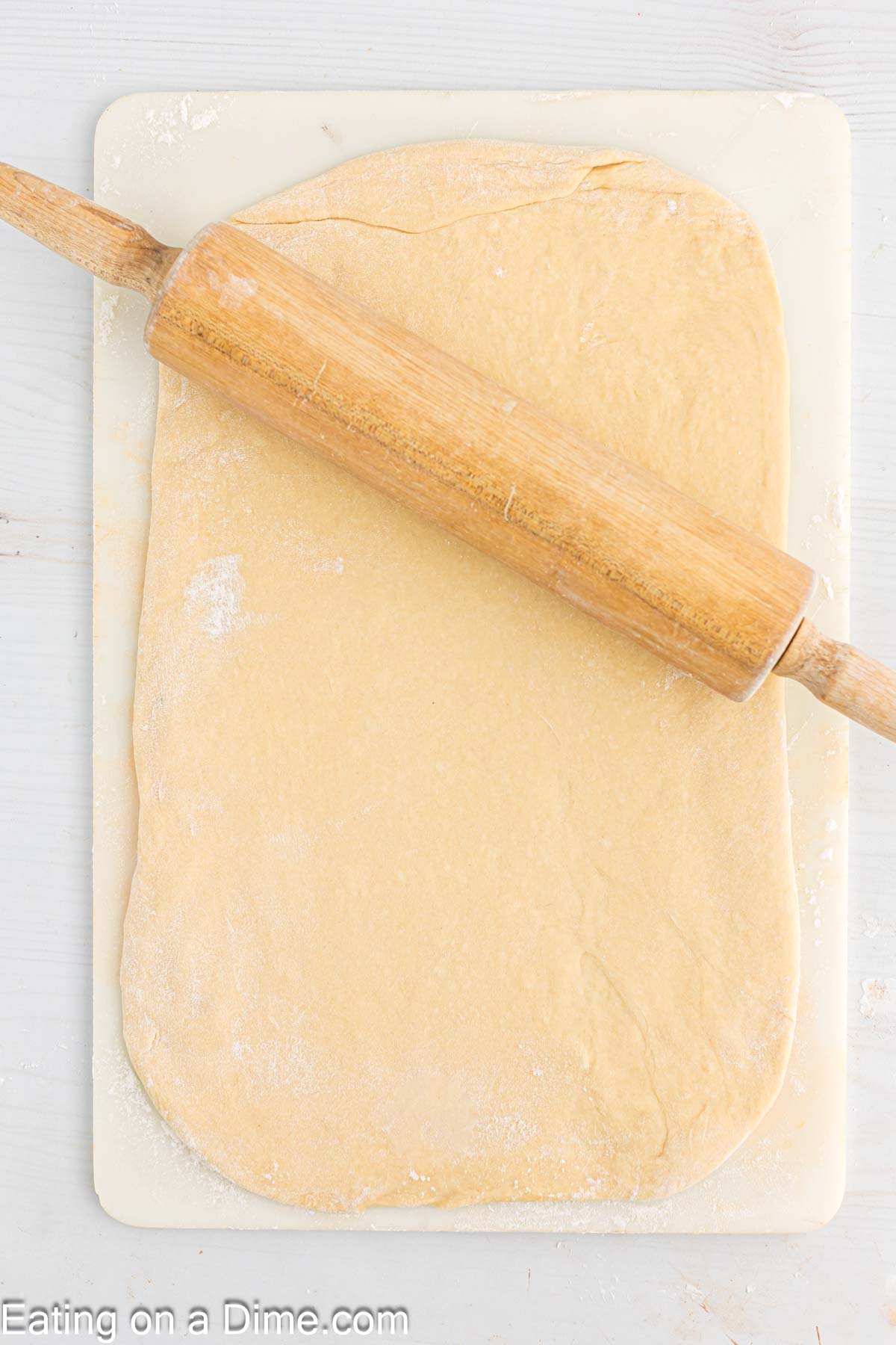 Rolling out the dough on a cutting board with a rolling pin