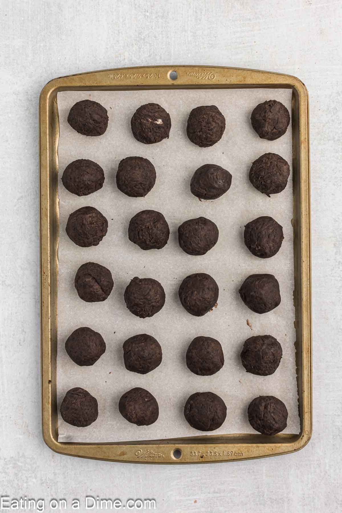 Rolling the Oreo crumbs into balls and placing on a baking sheet