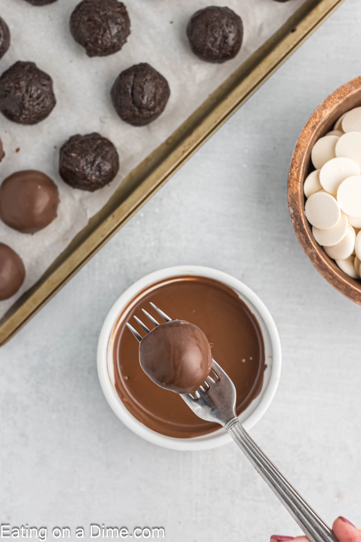 Dipping the Oreo Balls into the melted chocolate