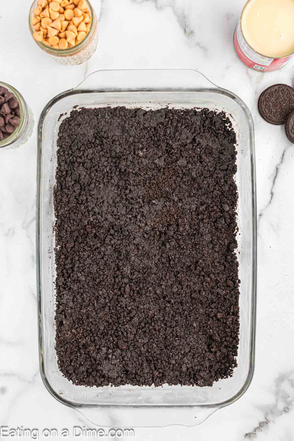 Pressing Oreo Crumbs in the bottom baking dish