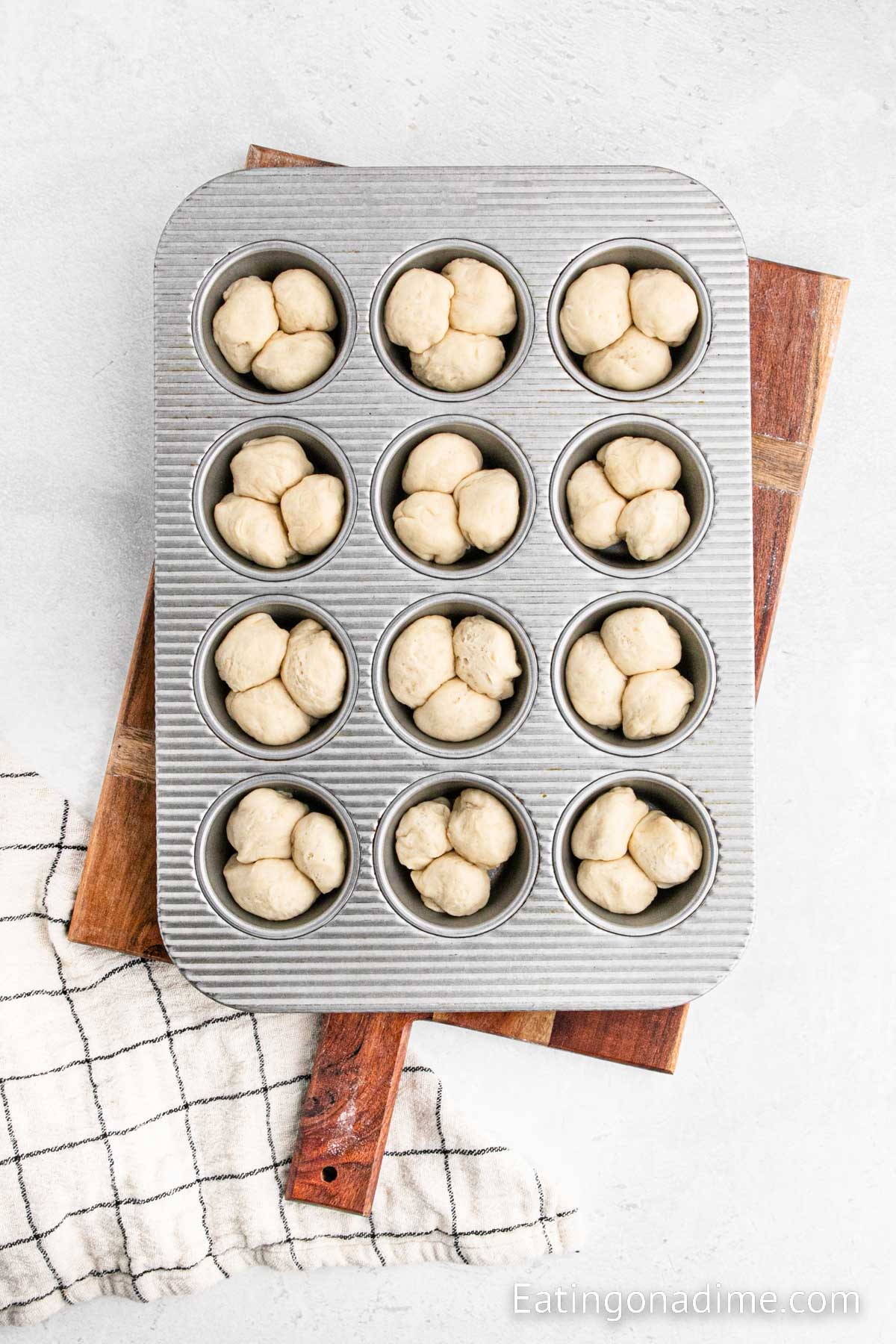 Placing the dough balls in a muffin tin