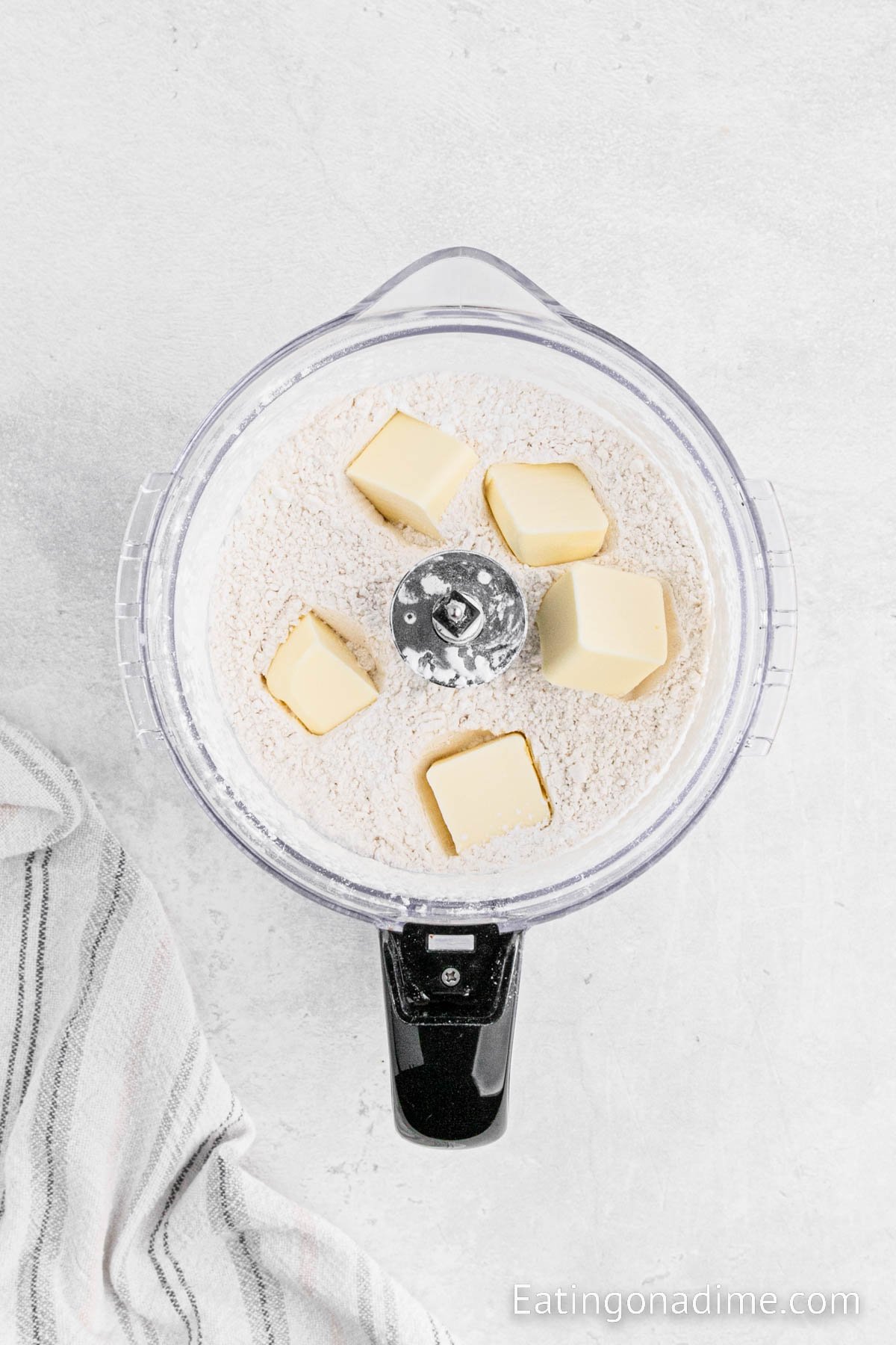 Adding the cold butter pieces in the flour mixture in the food processor