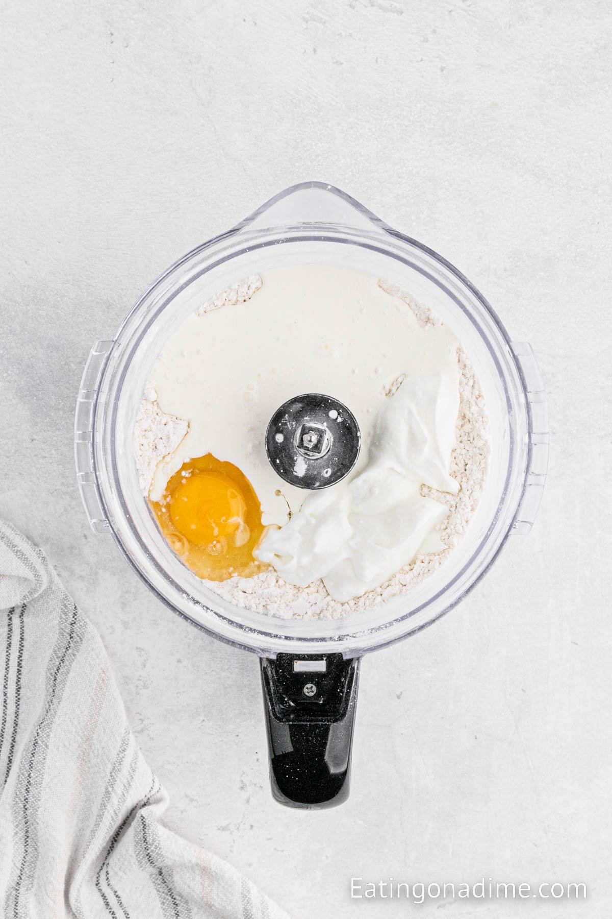 Adding the wet ingredients into the dry ingredients in a food processor