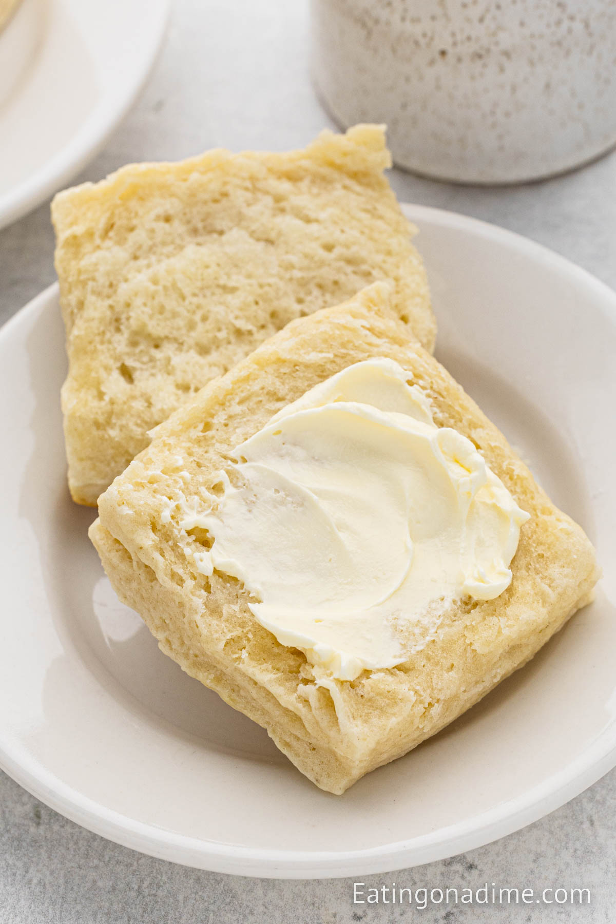 Homemade biscuits on a plate topped with butter
