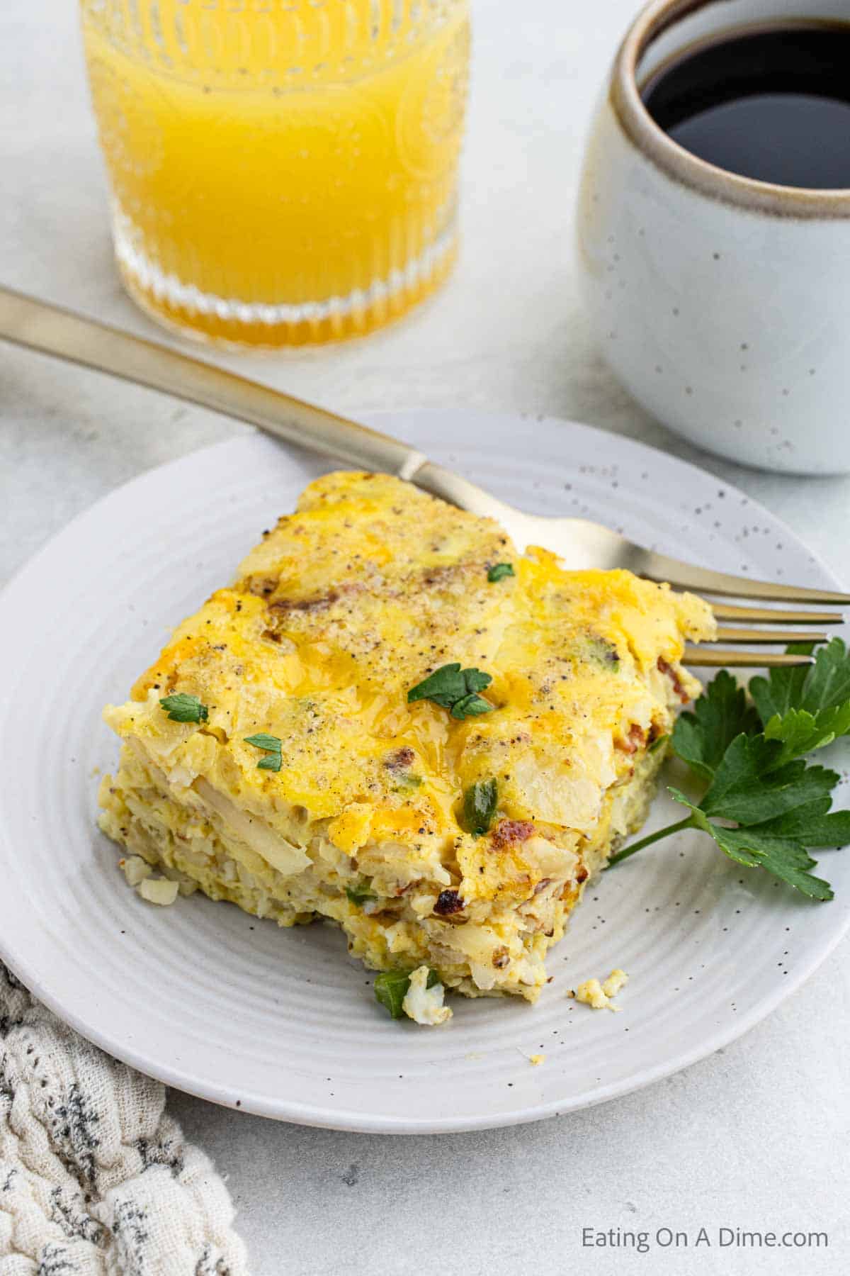 Slice of bacon casserole on a plate with a fork