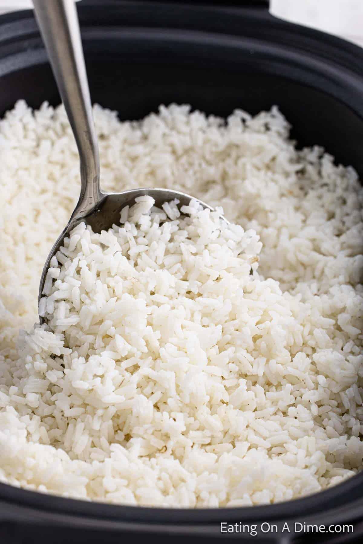 White rice in the slow cooker with a serving on a spoon