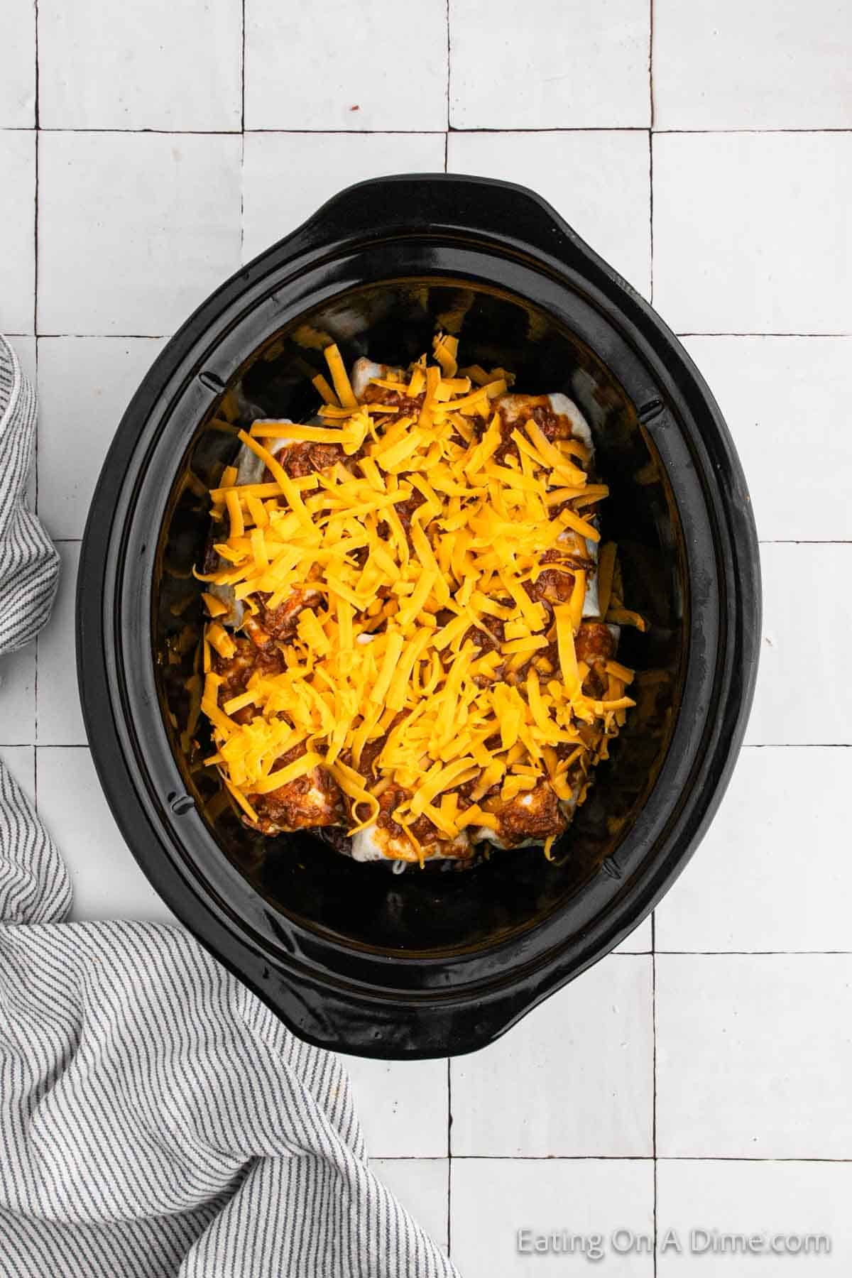 Topping the burritos with beef mixture and shredded cheese