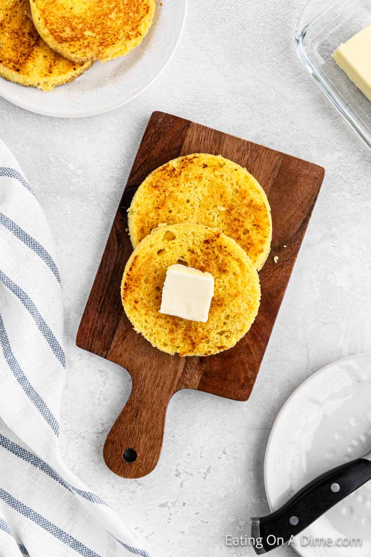 Keto bread sliced on a cutting board topped with butter