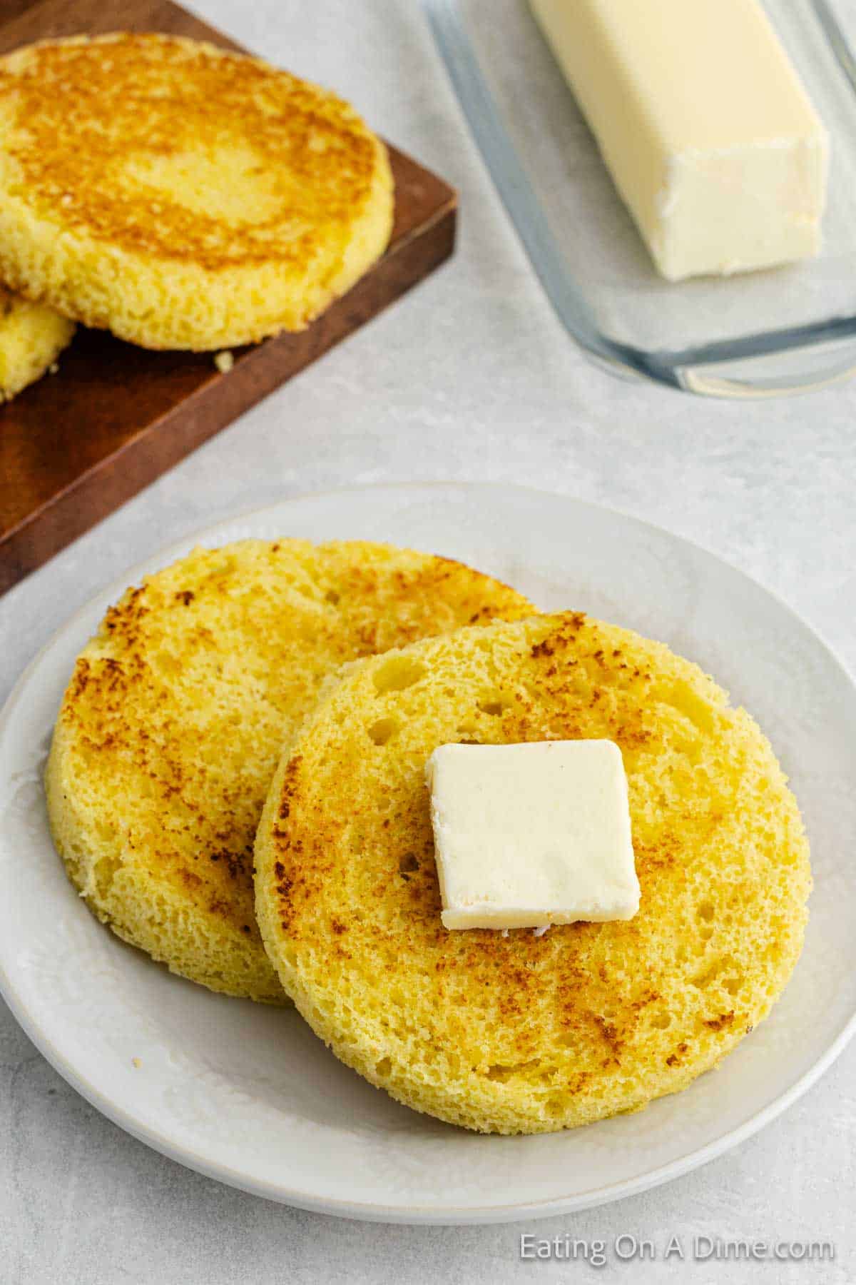 Keto bread sliced and topped with butter on a plate