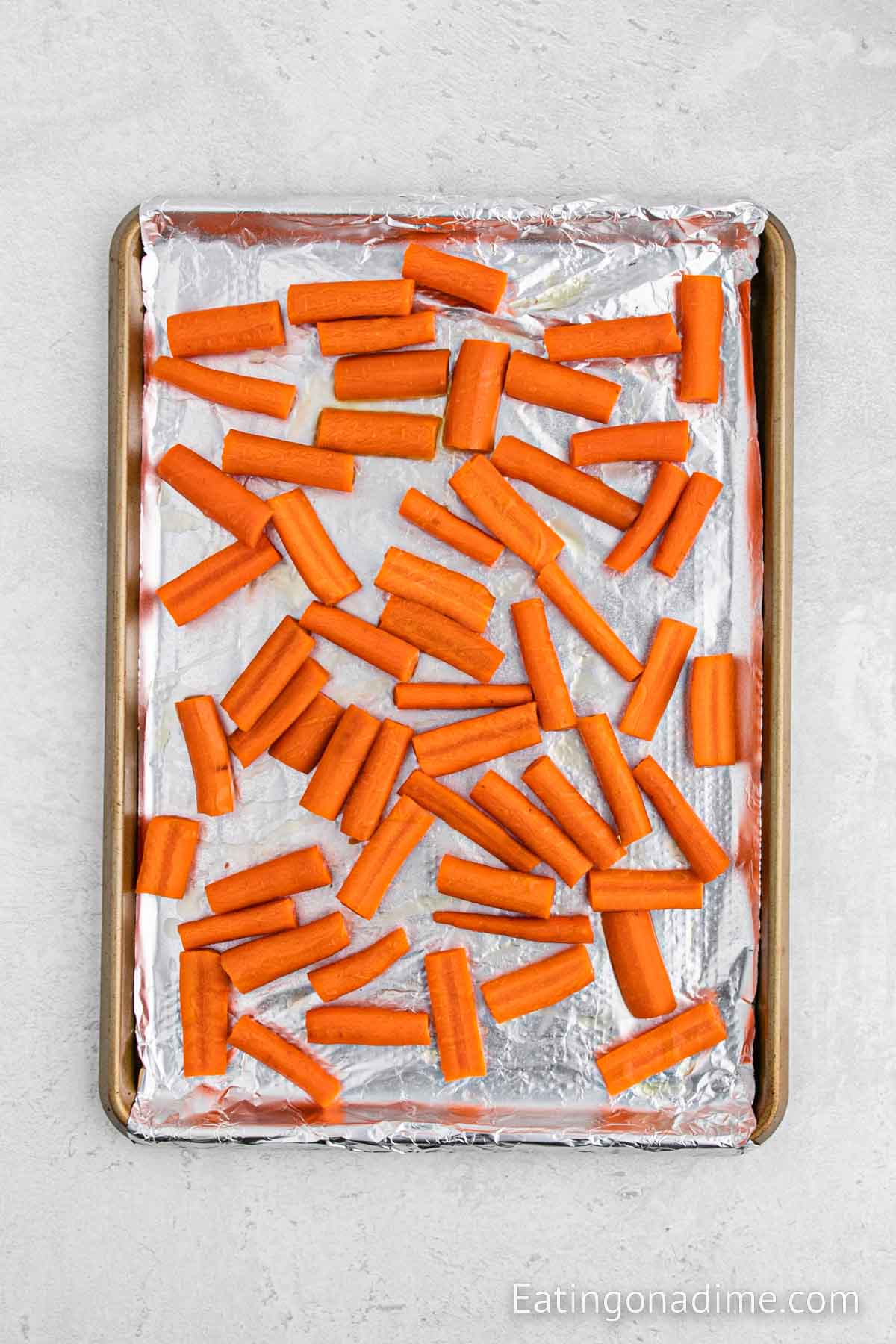 Placing the carrots on a foil lined baking sheet