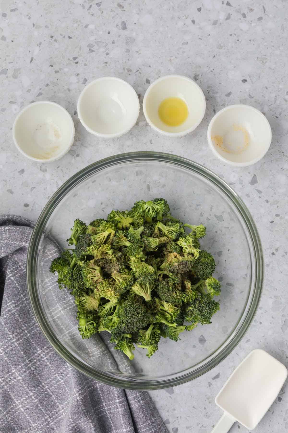 Fresh broccoli in a bowl topped with spices.