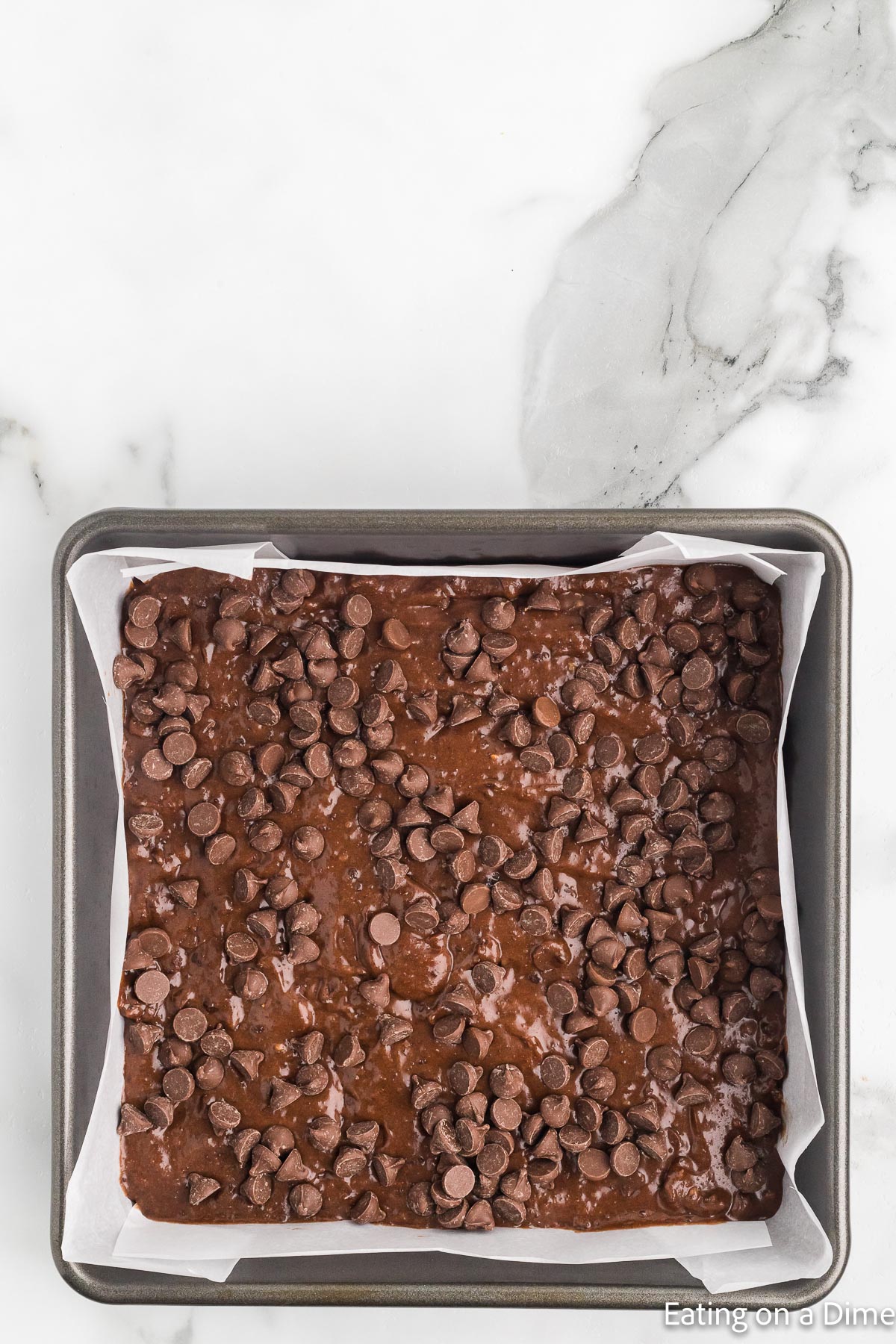 Topping the brownie batter with chocolate chips