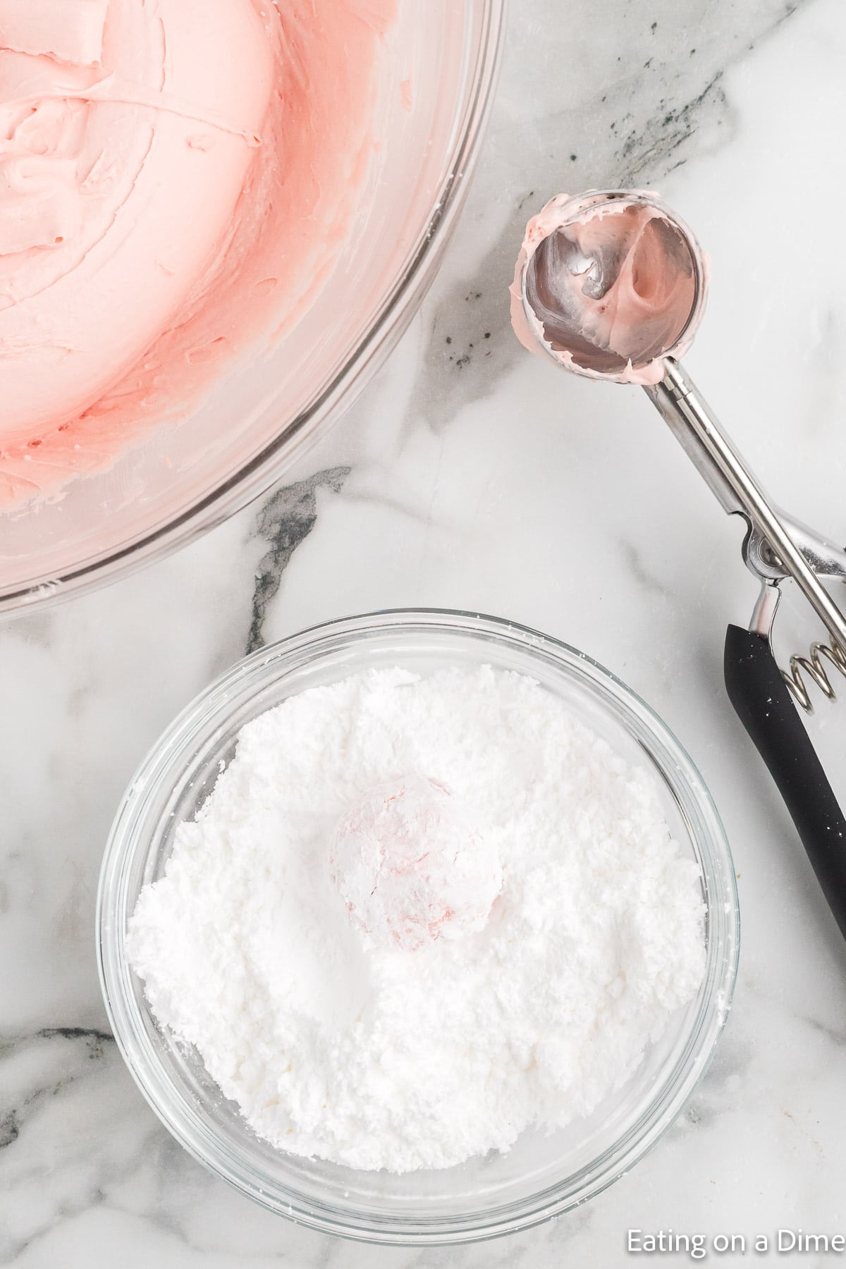 Rolling the cookie dough ball in powdered sugar