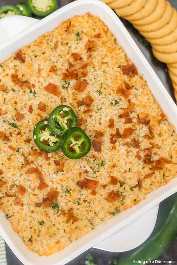Step up your appetizer game with this easy Jalapeno popper dip recipe. The entire dish is creamy with the perfect amount of heat and topped with panko and bacon. Jalapeno Popper Dip Recipe is the best hot dip and so cheesy. Everyone will love the delicious blend of cheesy bacon, cream cheese and jalapenos baked to perfection. Serve this simple appetizer warm and enjoy! #eatingonadime #jalapenopopperdiprecipe #easycreamcheeses #appetizers #jalapenopopperdippingsauce