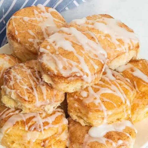 A plate of glazed biscuits with a blue and white striped napkin.