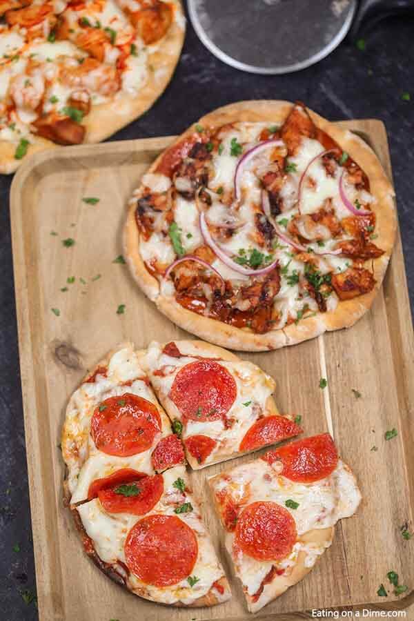 Enjoy this healthy Pita pizza recipe in minutes with the toppings of your choice. Skip takeout and make pita bread pizza for a quick and easy frugal dinner. Enjoy homemade mini pizza in the oven in minutes. The ideas are endless for pita pizza recipes and include buffalo chicken, BBQ Chicken and more. Kids love flatbread and pita pizza recipes. #eatingonadime #pitapizza #RecipesKids #healthycleaneating #lowcalorie 