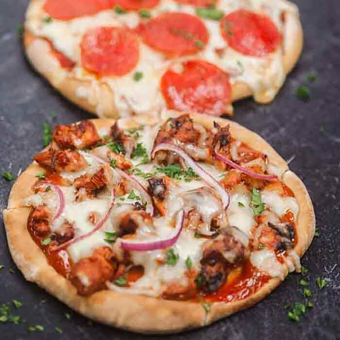 Enjoy this healthy Pita pizza recipe in minutes with the toppings of your choice. Skip takeout and make pita bread pizza for a quick and easy frugal dinner. Enjoy homemade mini pizza in the oven in minutes. The ideas are endless for pita pizza recipes and include buffalo chicken, BBQ Chicken and more. Kids love flatbread and pita pizza recipes. #eatingonadime #pitapizza #RecipesKids #healthycleaneating #lowcalorie 