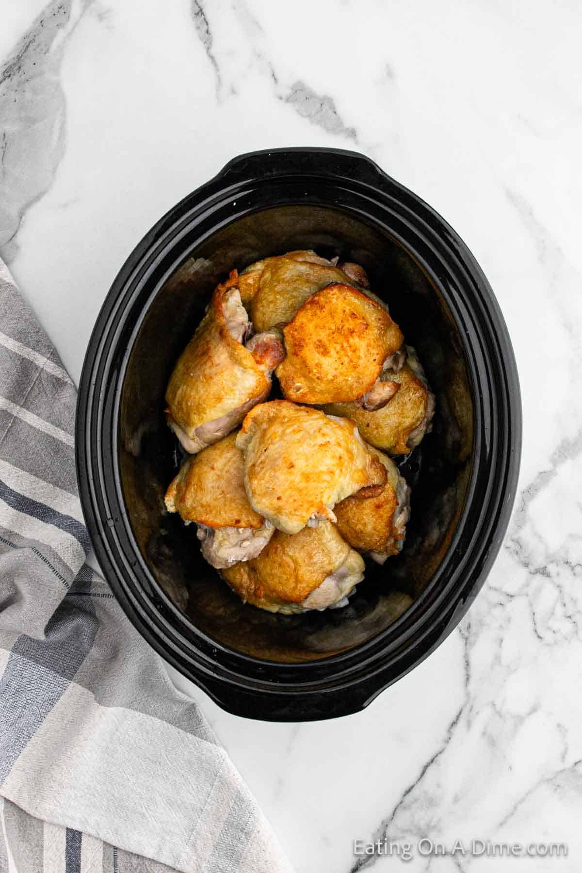 Placing chicken thighs in slow cooker