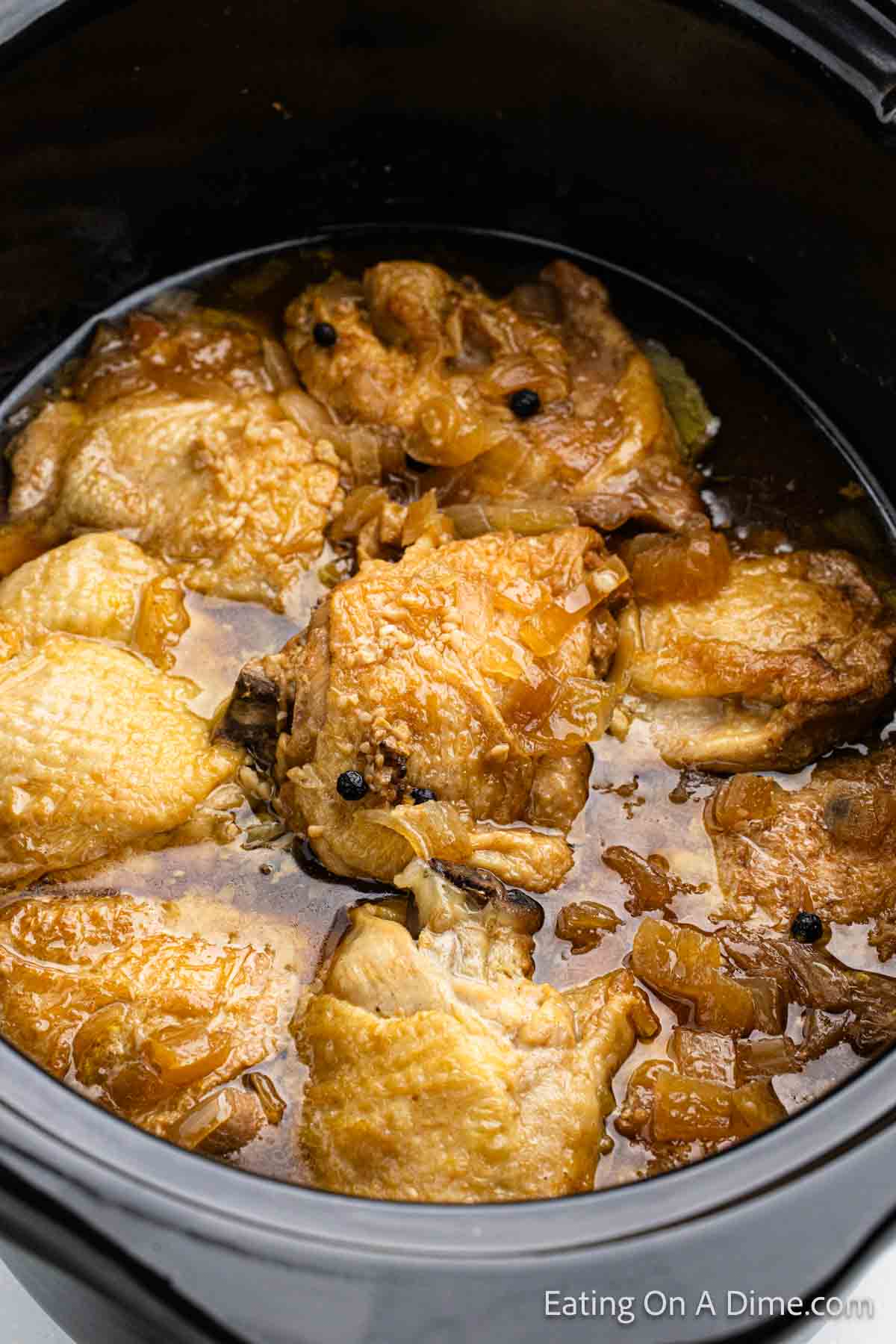 Cooked chicken in a sauce in the crock pot.