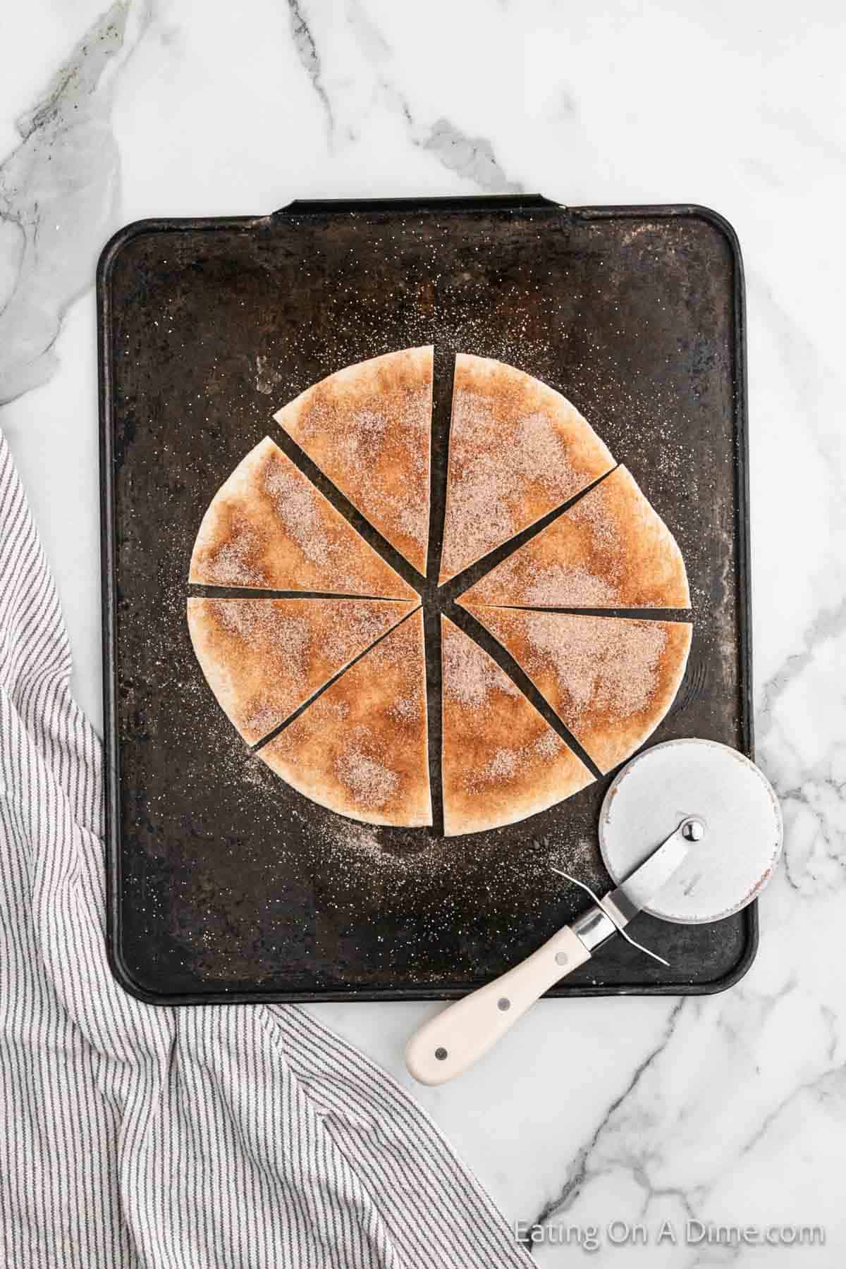 Cutting tortilla in the shape of tortilla with a pizza cutter