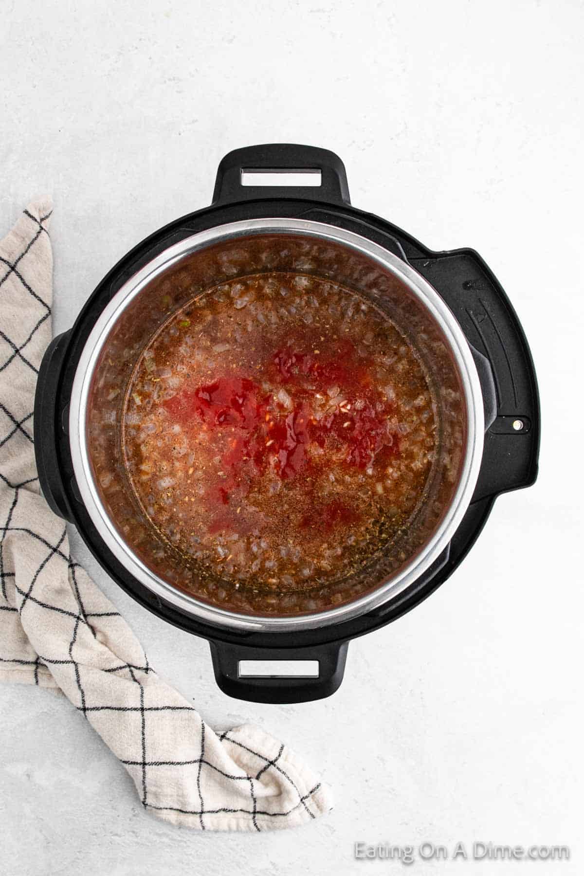 Tomato Sauce poured into the instant pot with the rice, onions and spices
