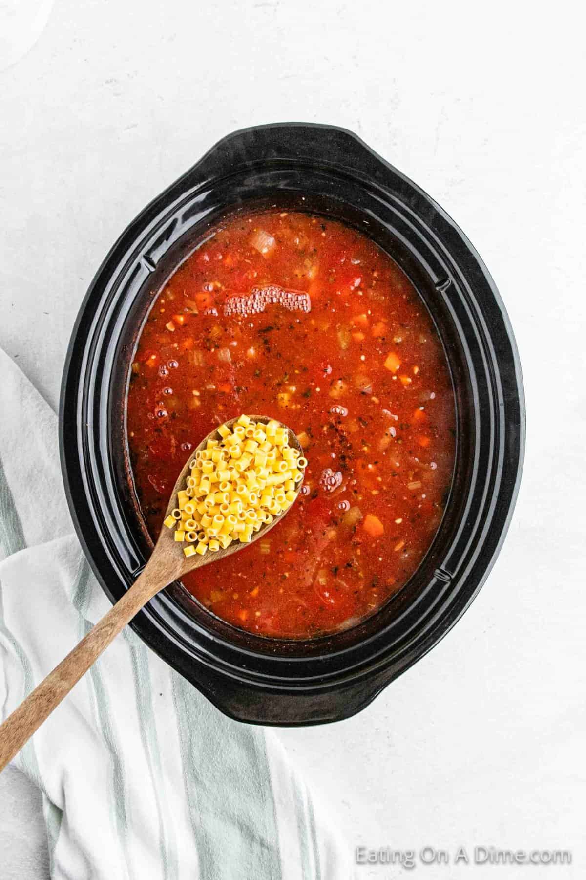 Stirring in the pasta into the cooked soup