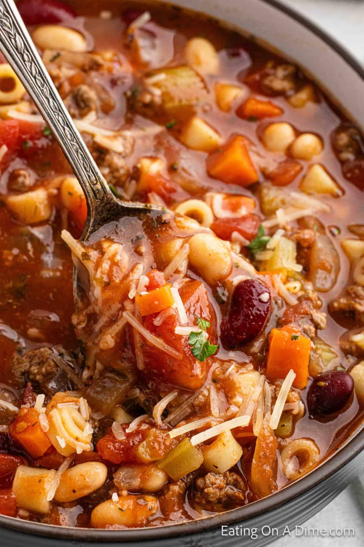 Close up image of pasta fagioli in a bowl with a bite on a spoon
