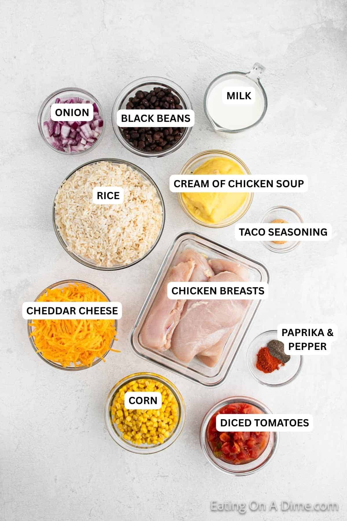 Ingredients for recipe: onion, black beans, milk, rice, cream of chicken soup, taco seasoning, cheddar cheese, chicken breasts, paprika, pepper, corn and diced tomatoes.