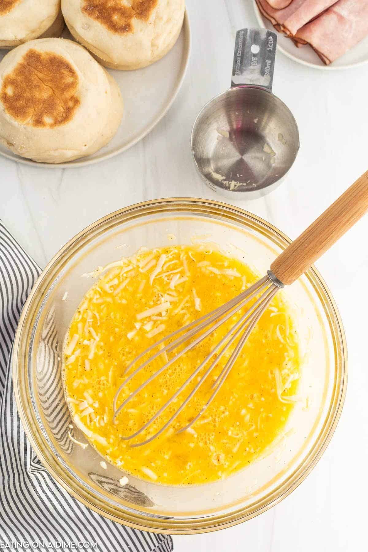 Whisking the eggs, milk, salt and pepper together in a bowl with the mozzarella cheese