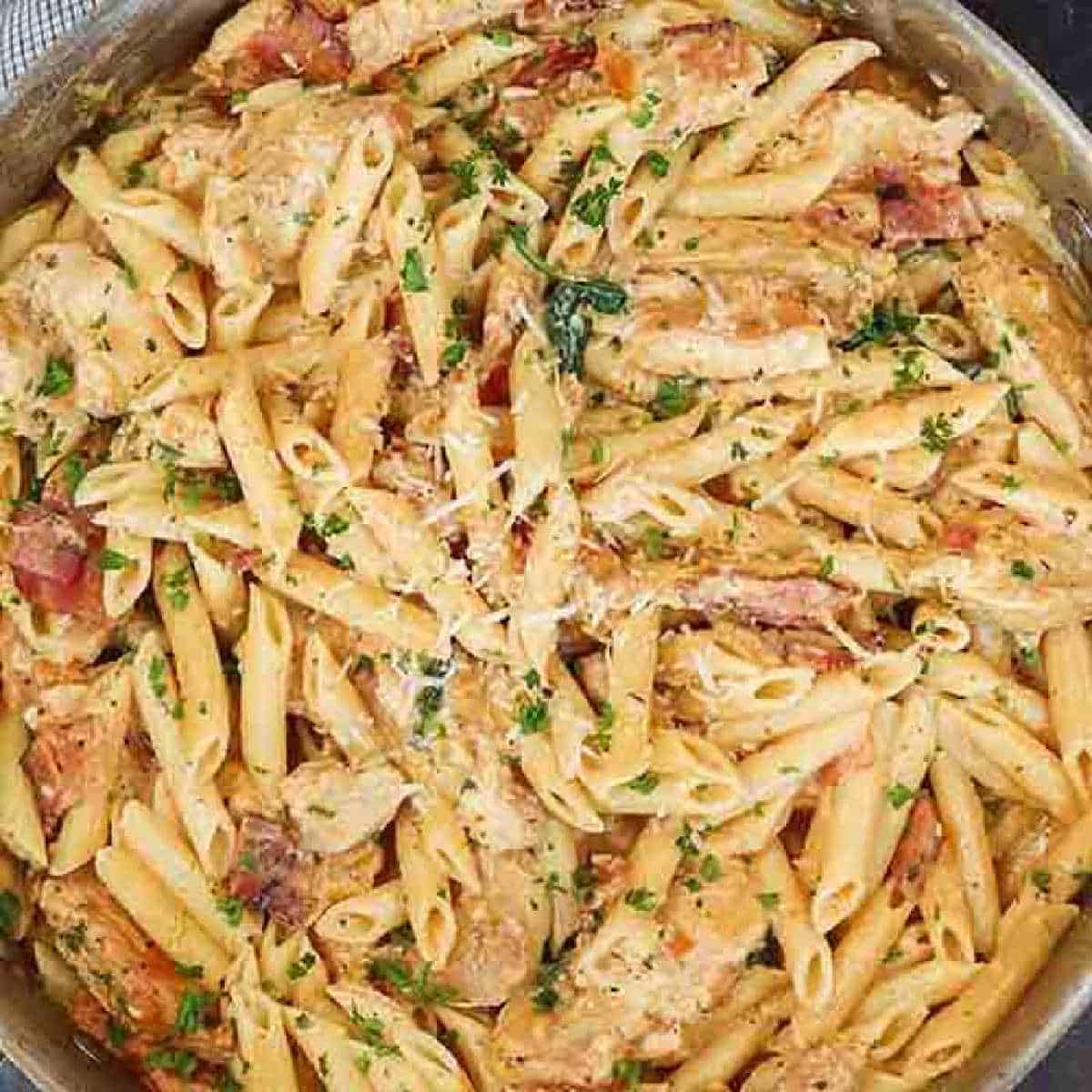 Close up of chicken pasta in a large skillet.