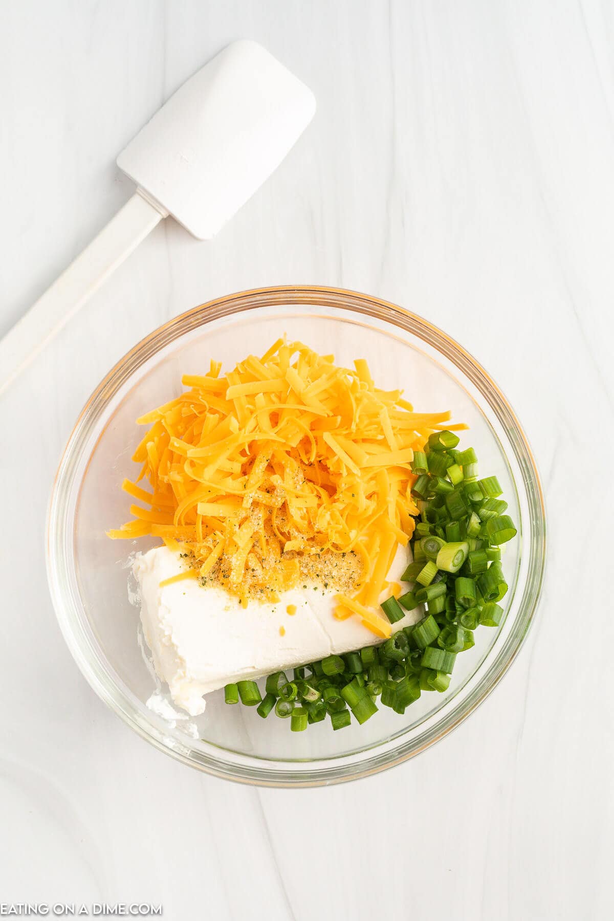 Combining the cream cheese, shredded cheese and green onions in a bowl