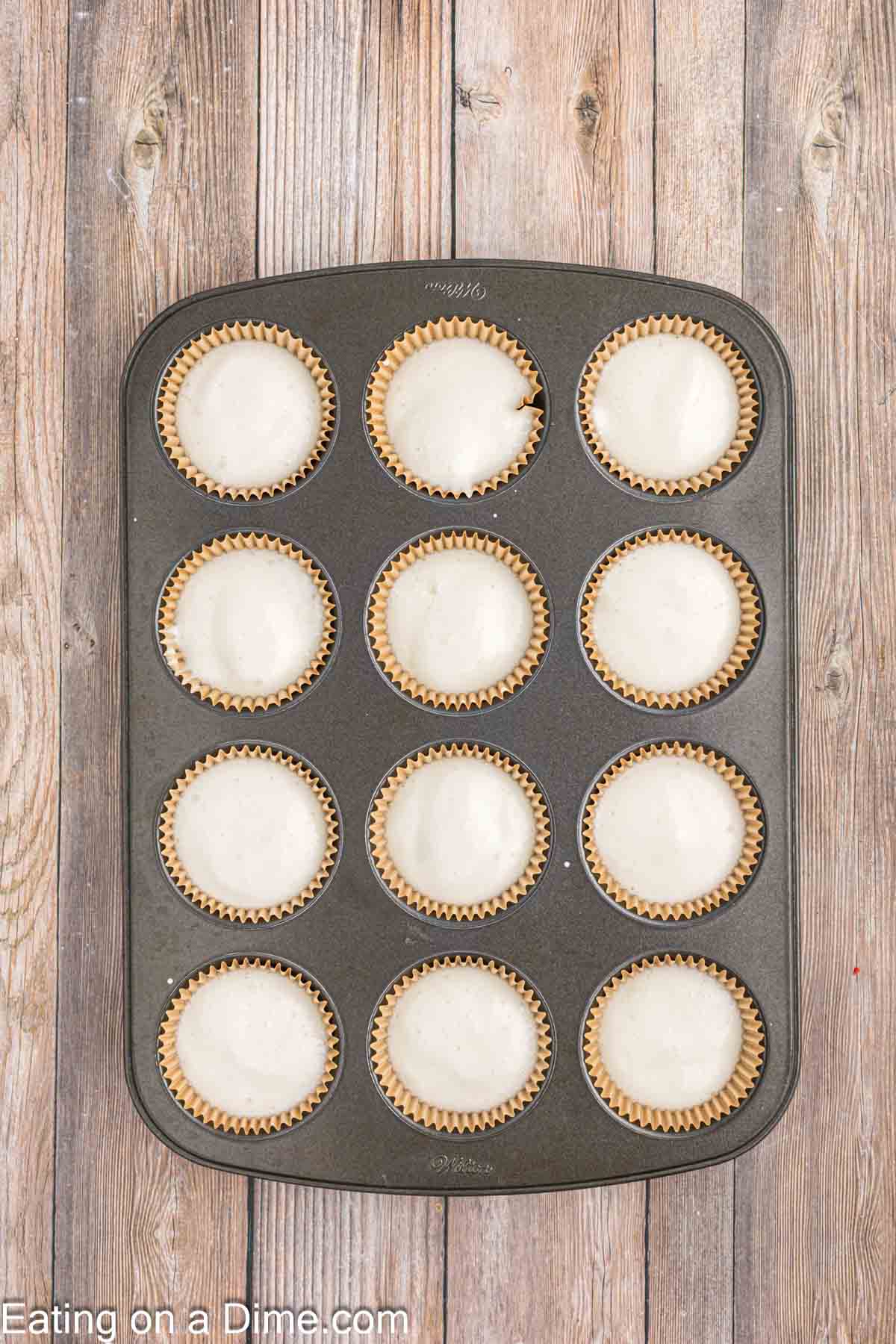 Placing the angel food cake batter into the muffin tin