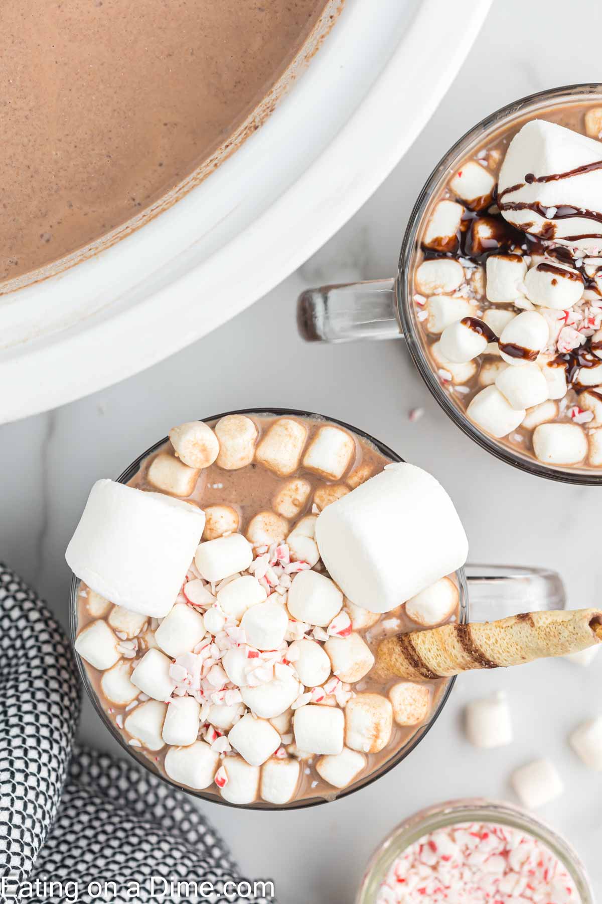 Hot Chocolate in a clear mug topped with marshmallows chocolate syrup and crushed peppermint