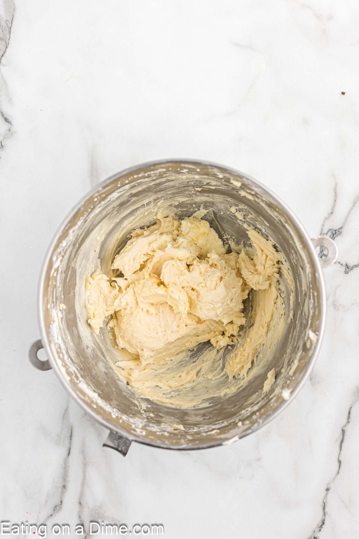 Adding in the powdered sugar to the butter mixture for the frosting in a bowl