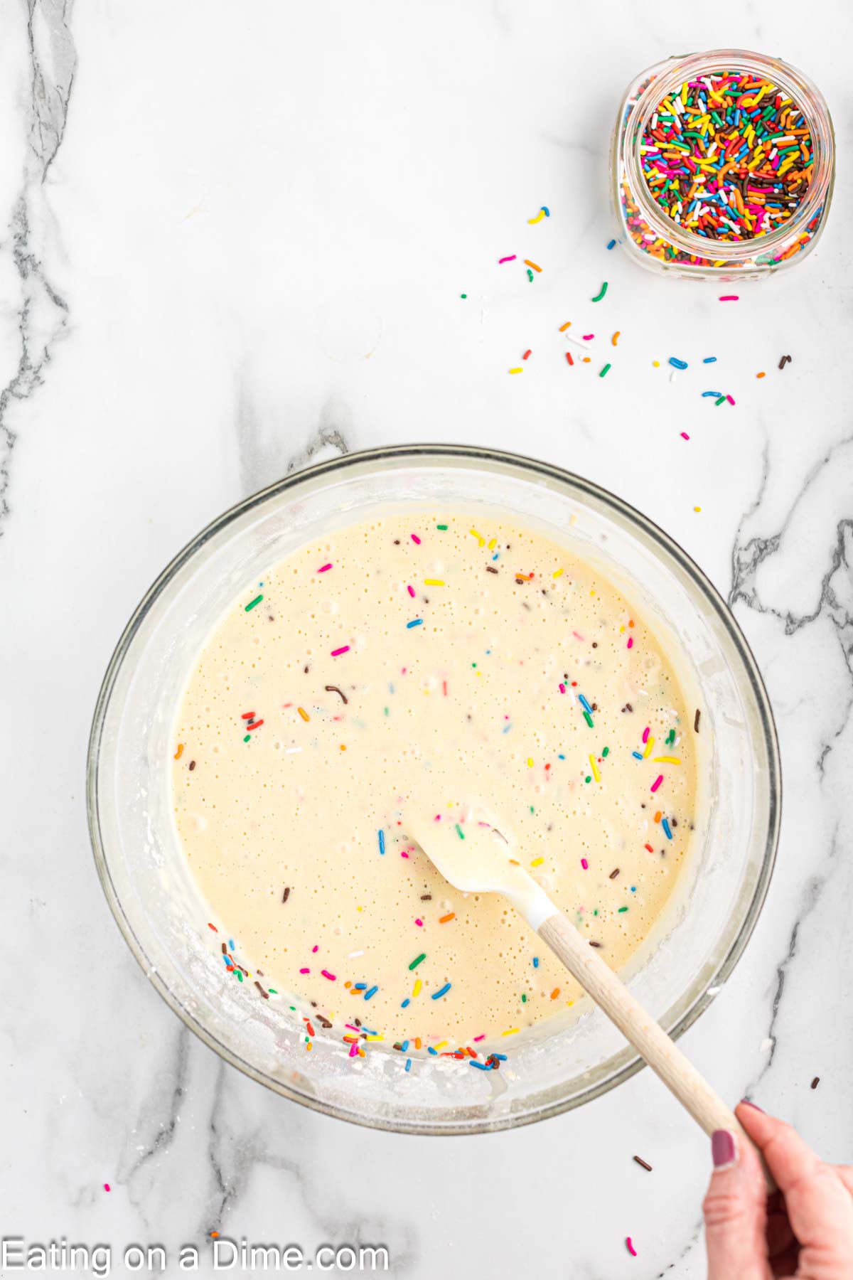 Mixing in the sprinkles into the cupcake batter