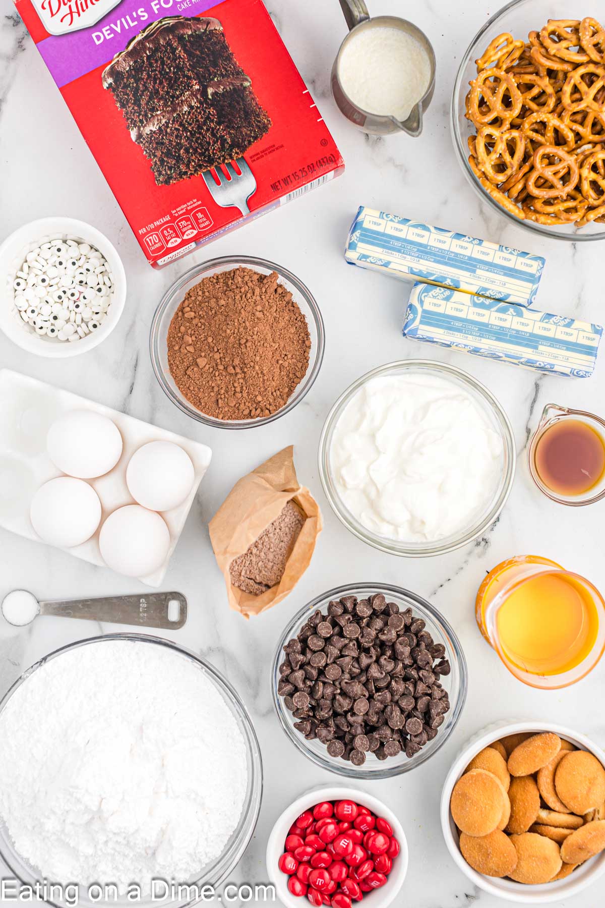 Ingredients needed - Devil's Food Cake Mix, chocolate pudding, chocolate chips, eggs, oil, water, sour cream, butter, powdered sugar, cocoa powder, heavy cream, vanilla extract, salt, pretzel twists, nilla wafers, red M&M, candy eyeballs