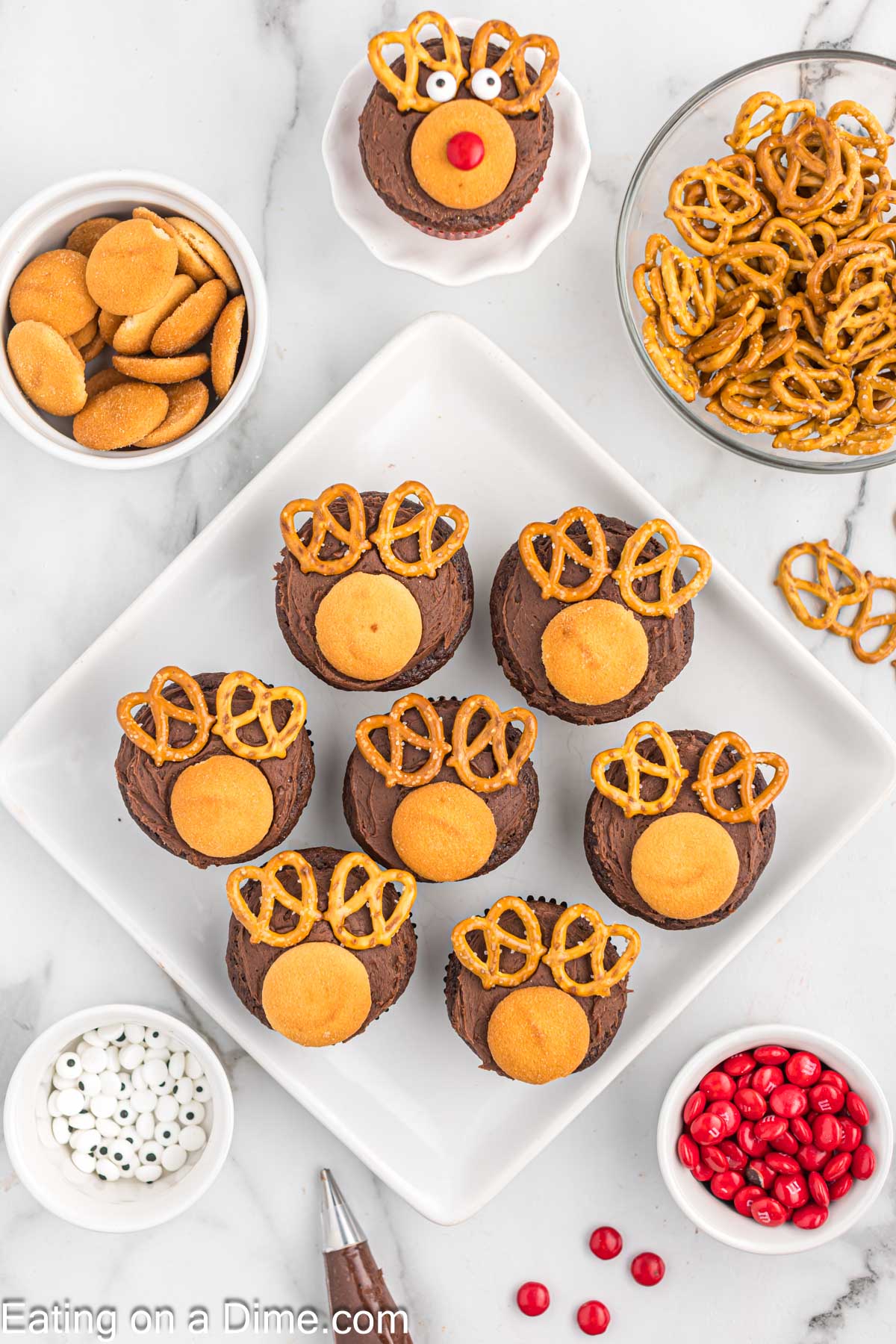 Topping the cupcakes with pretzels and nilla wafers
