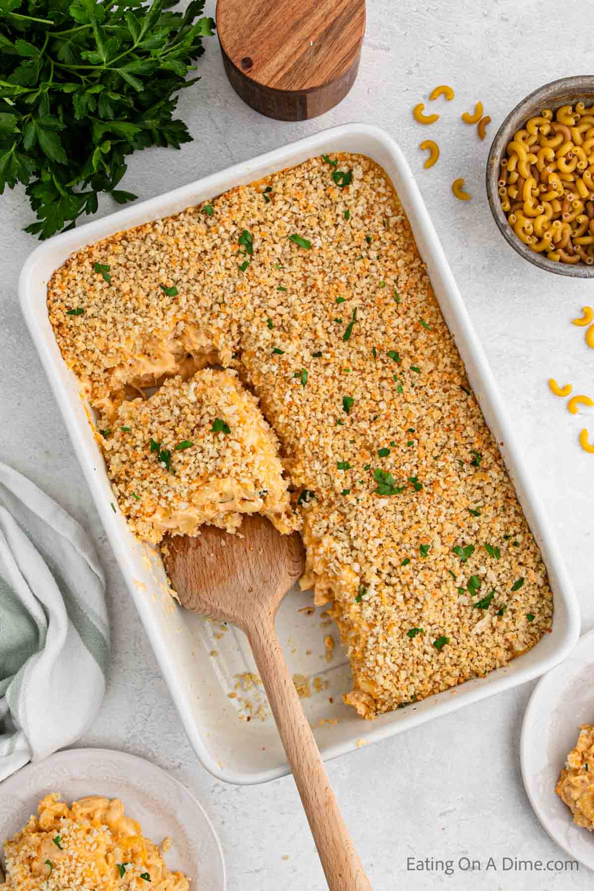 Baked Mac and Cheese in a casserole dish with a wooden spatula