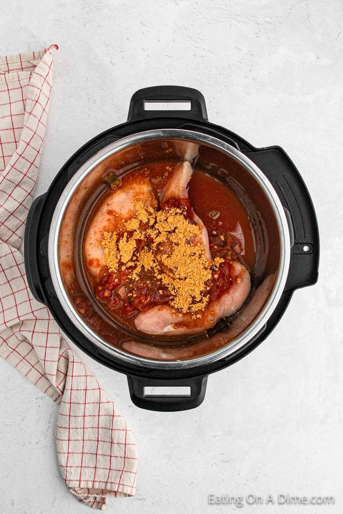 Chicken breast in the instant pot topped with salsa and taco seasoning